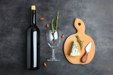 Mavi peynir, ahşap kesme tahtası ve siyah arka plan üzerine şarap şişe biberiye ile Dor mavi. Üstten Görünüm. Kavram peynir hizmet.