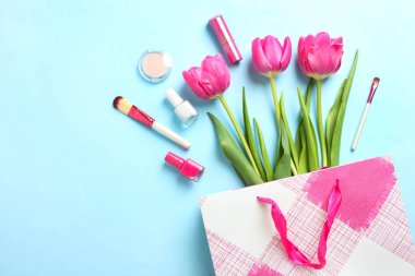 Paket ve kozmetik mavi arka plan üzerinde güzel Pembe Lale buketi. Kavram Dünya Kadınlar günü 8 Mart. Üstten Görünüm, kopya alanı,