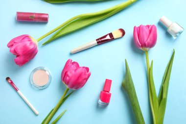Buket güzel pembe laleler ve kozmetik mavi zemin üzerine. Kavram Dünya Kadınlar günü 8 Mart. Üstten Görünüm, kopya alanı,