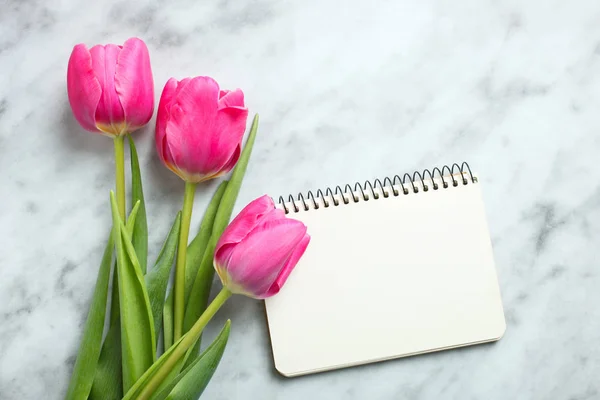 Ramo Hermosos Tulipanes Rosados Cuaderno Sobre Fondo Mármol Concepto Día — Foto de Stock