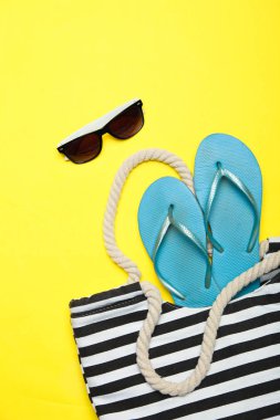 Siyah-beyaz çizgili plaj çantası mavi kauçuk ile flip flop ve su