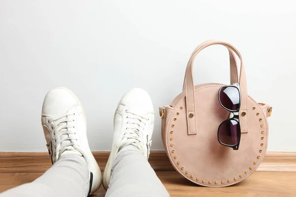 Bolso femenino redondo, gafas de sol y piernas de mujer en deportes sne — Foto de Stock