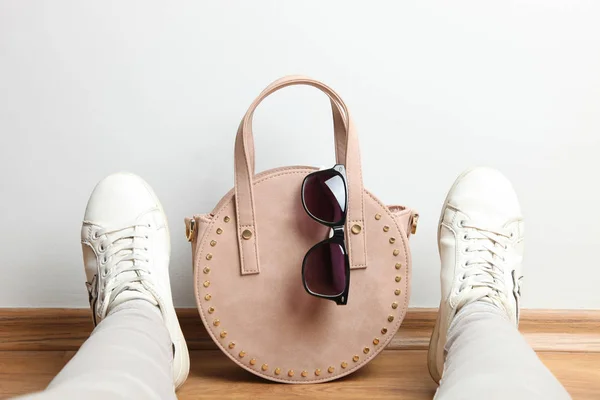 Bolso femenino redondo, gafas de sol y piernas de mujer en deportes sne — Foto de Stock