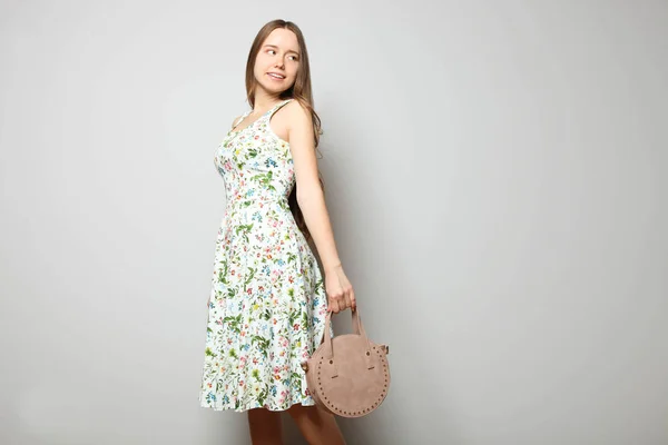 Chica en vestido con estampado floral y bolso redondo para mujer — Foto de Stock