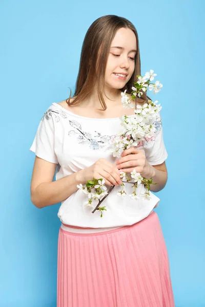 Mädchen in modischer Frühlingskleidung mit blühendem Zweig — Stockfoto