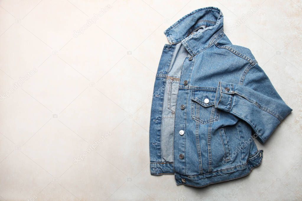 Stylish fashionable denim jacket on neutral background. Concept clothes. opy space, top view.