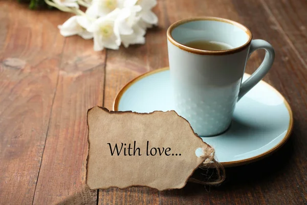 Csésze forró tea, jegyzet és csokor virág — Stock Fotó