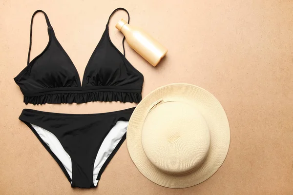Fato de banho preto feminino, chapéu de palha de praia e protetor solar — Fotografia de Stock