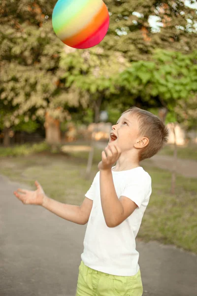 Niño jugando con brillante bola multicolor — Foto de Stock