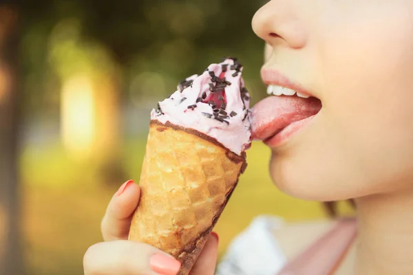Holka olizuje její jazyk osvěžující růžovou zmrzlinu — Stock fotografie