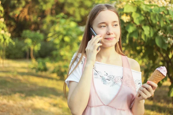 Chica hablando por teléfono y comiendo helado — Foto de Stock