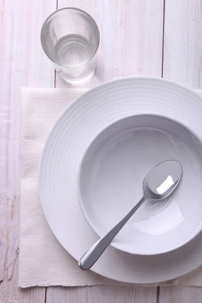Platos blancos con cuchara y vaso de agua —  Fotos de Stock