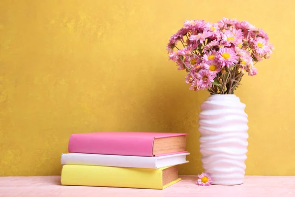 Libros y jarrón con ramo de crisantemos —  Fotos de Stock