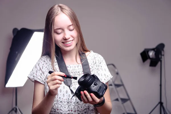 Fotógrafo para limpar a câmera reflexa óptica — Fotografia de Stock