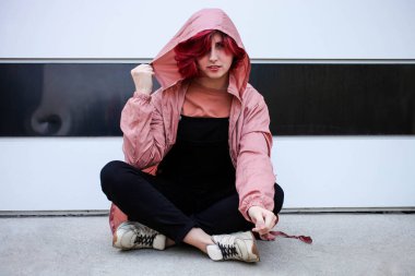 Sonbahar kıyafetleri içinde kısa pembe saçlı kız.