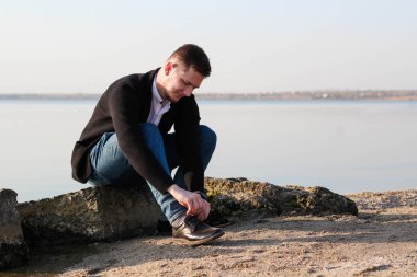 Siyah ceketli adam. Ayakkabı bağı. 