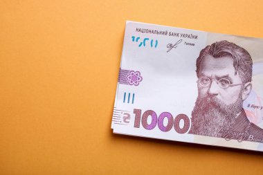 Yeni Ukrayna banknotları turuncu arka planda bin hryvnia.