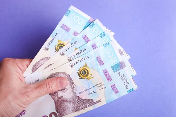 Yeni Ukrayna banknotları mavi arka planda bir kadın elinde binlerce hryvnia.