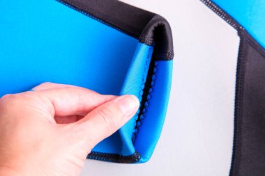 Kadın eli, neoprene maddesinin kalınlığını kontrol eder..