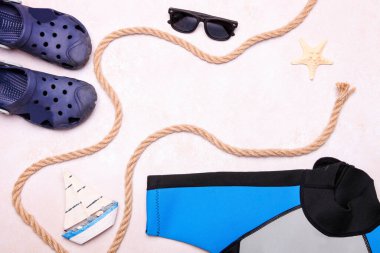 Çocuk neoprene kostümü ve beyaz arka planda aksesuarları olan lastik sandaletler. Yat.