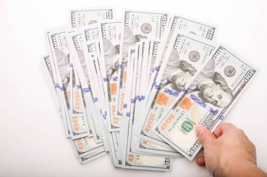 Beyaz arka planda 100 dolarlık banknotlar var..