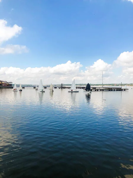 A group of children on sailing boats on the river. Yachting