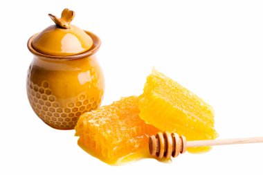 Beyaz arka planda izole edilmiş altın kesimli bal peteği ve ahşap kaşık.