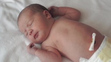 bebeklik, çocukluk, gelişim, tıp ve sağlık konsepti - yeni doğmuş çıplak yüzün yakın çekimi sakin uyanık bebek suratları sırt üstü uzanmış beyaz bej arka planda tıbbi klipslerle