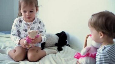 Çocukluk, ev sineması, aile, karantina, kişisel yalnızlık kavramları. Kardeşler yumuşak oyuncaklarla oynarlar. Erkek ve kız kardeş birlikte şarkı söyler ve dans ederler, sessizce hareket ederler. Çocuklar evde eğleniyor.
