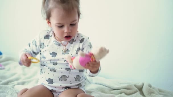 Enfance, divertissement, jeux, quarantaine, auto-isolement, concepts. Petite fille souriante en blanc montre différentes émotions tristesse, ennui, joie, bonheur, rire.kid jouer avec des jouets musicaux à la maison — Video