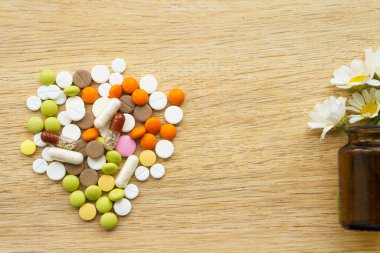 İlaç ve sağlık, ilaç, ilaç, koronavirüs, salgın, salgın konsepti - ilaçlara karşı doğal bitkisel ilaçlar. Dağınık renkli haplar ve papatya kopyası, selandin kopyası