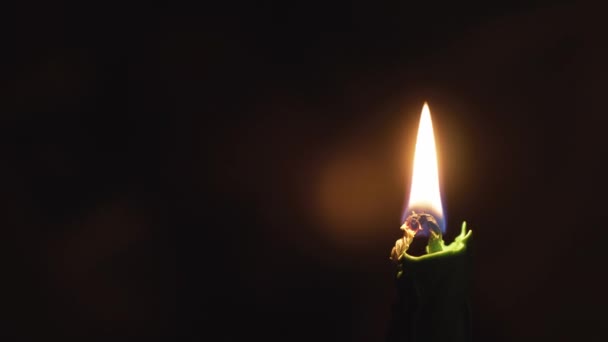 Religione, cristianesimo, ortodossia, vacanze, concetto di culto - Una singola candela verde accesa sullo sfondo dell'icona del volto di Gesù Cristo nelle tenebre dell'altare della chiesa ortodossa cristiana russa — Video Stock