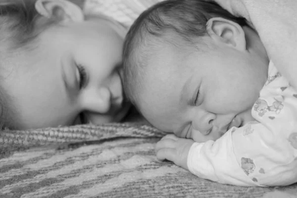 Infância, infância, família, sono, descanso, conceitos de amor. Visão de close-up preto e branco de duas crianças, bebê recém-nascido e menina dormindo juntos em cama macia. irmãos estão dormindo no sofá em casa . — Fotografia de Stock