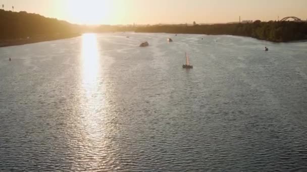 Transprt, reservoarer, resor, navigering koncept - antenn undersökning från höjd bro ower damm med båtar båtar yachter och andra turistfartyg vatten på bred flod Dnipro i Kiev vid solnedgången. — Stockvideo