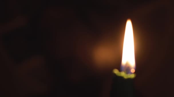 Religión, cristianismo, ortodoxia, vacaciones, concepto de culto - Una sola vela verde ardiente sobre el fondo del icono de la cara de Jesucristo en la oscuridad del altar de la iglesia ortodoxa cristiana rusa — Vídeo de stock