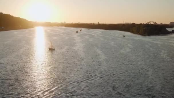 Transprt, reservoarer, resor, navigering koncept - antenn undersökning från höjd bro ower damm med båtar båtar yachter och andra turistfartyg vatten på bred flod Dnipro i Kiev vid solnedgången. — Stockvideo