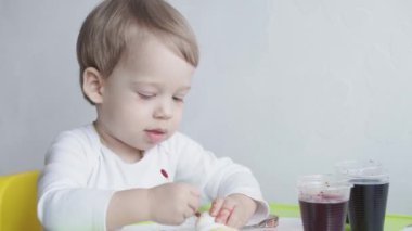 Çocukluk, uyku, rahatlama, aile, yaşam tarzı konsepti. 2 ve 3 yaşlarındaki iki küçük çocuk beyaz ve bej renkli giysiler içinde öğle yemeğinde el ele tutuşarak bej ve beyaz bir yatakta uyurlar.