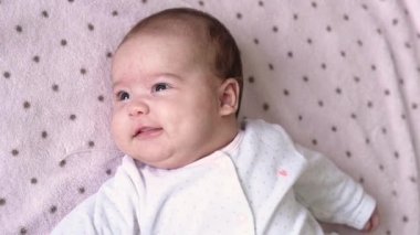 bebeklik, çocukluk, gelişim, tıp ve sağlık konsepti - yeni doğan çıplak yüz canlı bebek gülüşleri ve kahkahalar pembe arka plandaki beşiğinde uzanan oyuncağa uzanın.