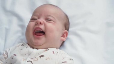 bebeklik, çocukluk, gelişim, tıp ve sağlık konsepti - yeni doğan çıplak yüz canlı bebek gülüşleri ve kahkahalar beyaz arka planda beşikte uzanan oyuncağa uzanın.