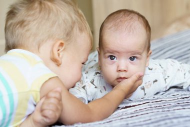 İki çocuk yatakta uzanıp kucaklaşıyor. Ağabeyi yerde yatıyor, sarılıyor ve yeni doğmuş kardeşinin elini tutuyor. Çocukluk ve aile kavramı