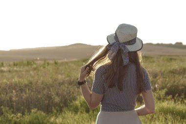 Kadınlık, kaynak stili, mutluluk, doğa, yaz, tatil - saman şapkalı mutlu genç kız Kafkas Slav görünüşü yaz günbatımında lavanta tarlasında gülümsüyor ve dinleniyor. Boşluğu kopyala
