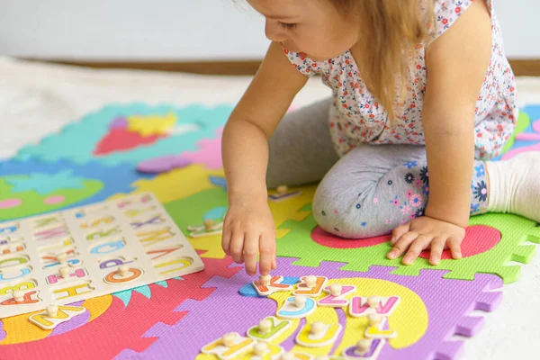 학교 준비중이야. 어린 아이를 위한 교육. 유치원의 취학 전 교육. 아이들은 집 바닥에서 알파벳으로 퍼즐을 만듭니다 . 아이들을 위한 색 영어 알파벳알 파베입니다. 배의 퍼즐 — 스톡 사진