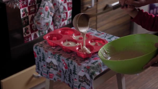 Navidad, invierno, año nuevo, celebración, familia, hornear, preparación, concepto de cocina - Madre joven prepara pasteles con su hijo pequeño de pie cerca del horno en la cocina decorada en Navidad — Vídeos de Stock