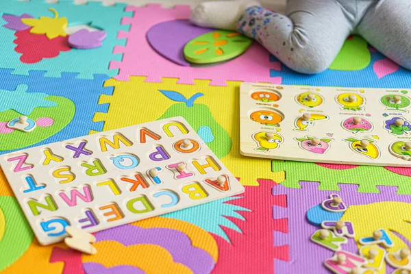 Je me prépare pour l'école. L'éducation pour les plus jeunes. Éducation préscolaire dans les jardins d'enfants. petit enfant fait des puzzles à partir de l'alphabet sur le sol à la maison.Couleur Alphabet anglais pour les enfants. puzzles à bord — Photo