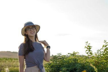 Kadınlık, kaynak stili, mutluluk, doğa, yaz, tatil - saman şapkalı mutlu genç kız Kafkas Slav görünüşü yaz günbatımında lavanta tarlasında gülümsüyor ve dinleniyor. Kopya alanı