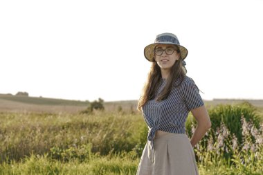 Kadınlık, kaynak stili, mutluluk, doğa, yaz, tatil - saman şapkalı mutlu genç kız Kafkas Slav görünüşü yaz günbatımında lavanta tarlasında gülümsüyor ve dinleniyor. Boşluğu kopyala