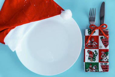 Xmas, kış, yeni yıl konsepti - Kırmızı altın ve beyaz ağaç oyuncaklarıyla mavi Noel arkaplanı, masa düzenleme, restoran. Beyaz boş tabak ve keski. Düz, üstten, tepeden. Boşluğu kopyala.