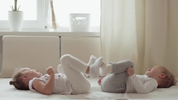 Familie Onschuld Baby Concepten Twee Lachende Kinderen Doen Beenoefeningen Liggend — Stockvideo