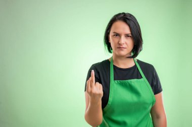 Female cook with green apron and black t-shirt, showing fuck you
