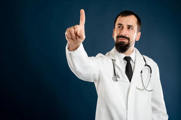 男性医師の肖像画とともに聴診器で医療制服は 仮想ボタンを押すと 青の隔離された背景にポーズ — ストック写真